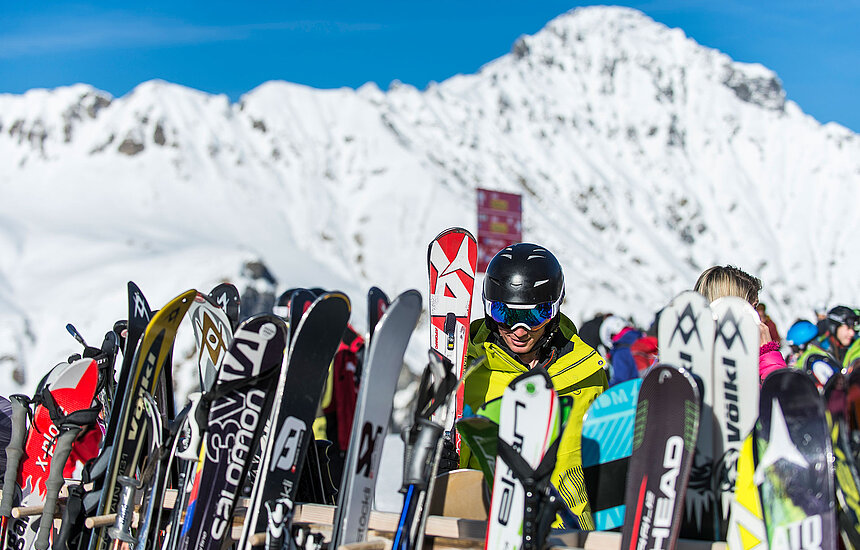 Verschiedene Skis mit Berglandschaft als Hintergrund