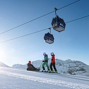 Zwei Skifahrer und ein Snowboarder auf der Skipiste