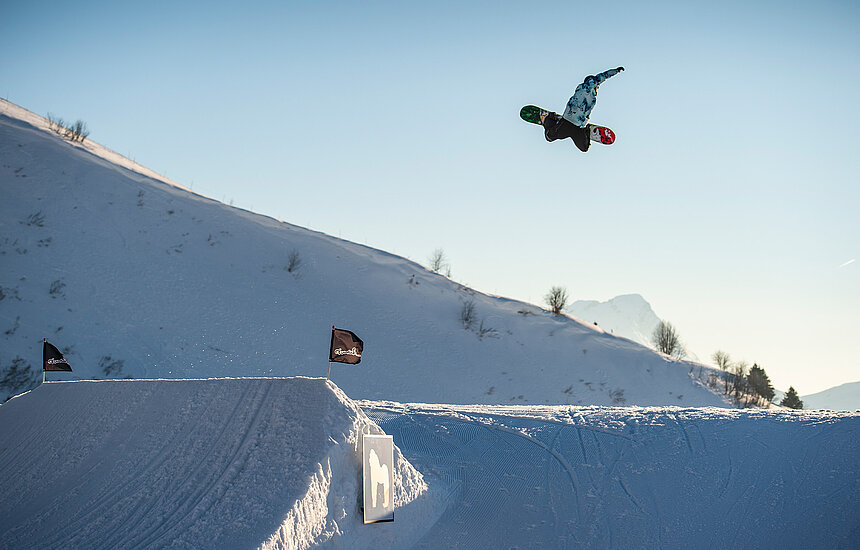 Snowboarder in Luft über Schanze